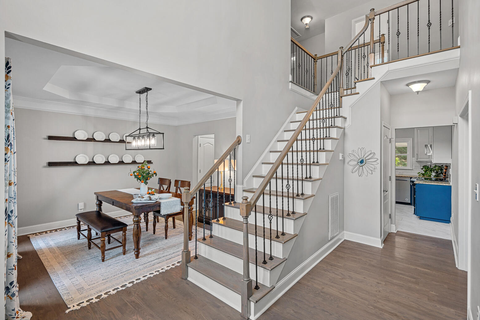 Two‑story entryway with hardwood floors and open staircase in Birkdale Huntersville home.